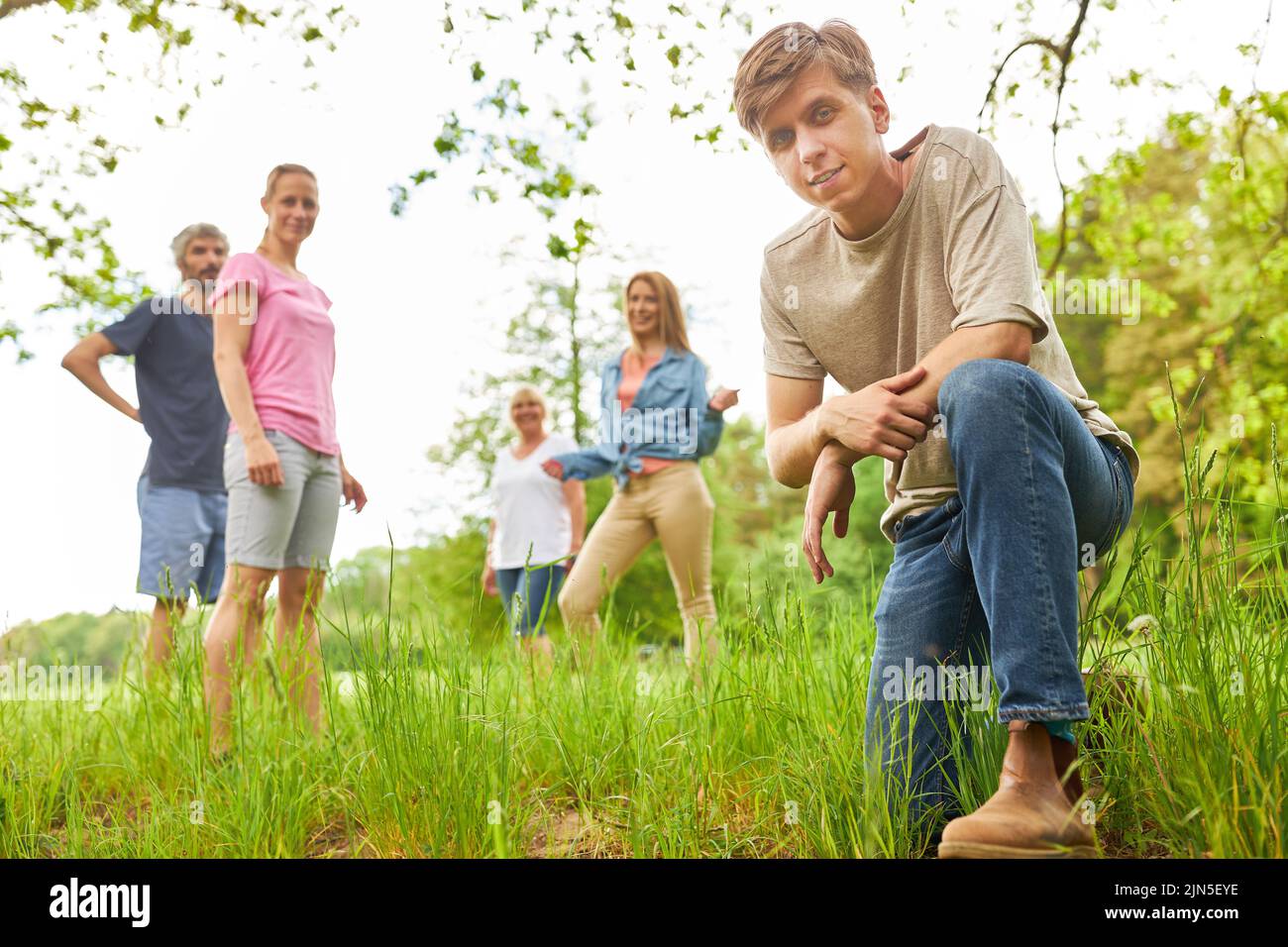 Young man and friends on a trip or hike in nature in summer Stock Photo