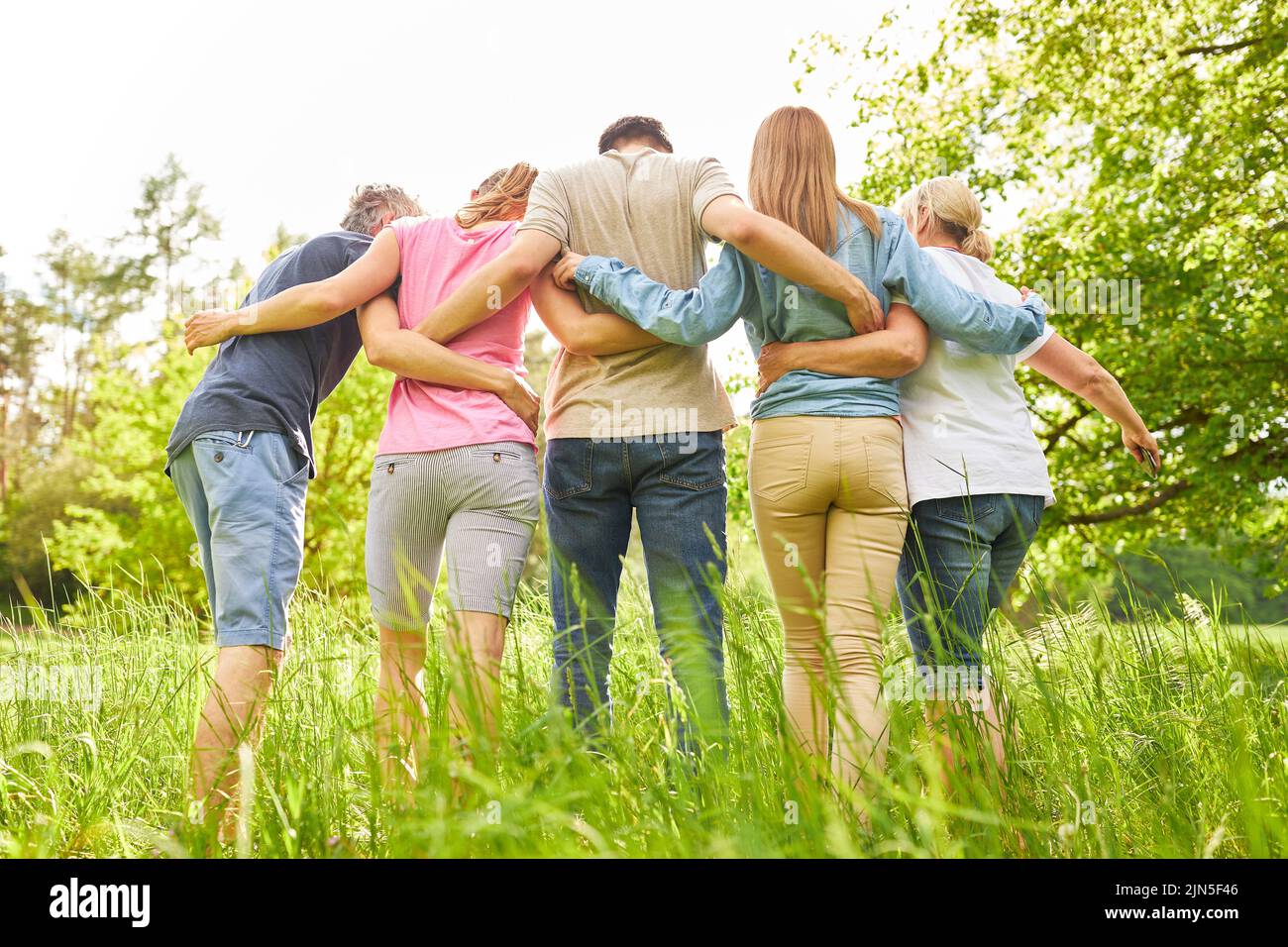 Family or group of friends arm in arm on a summer nature outing Stock Photo