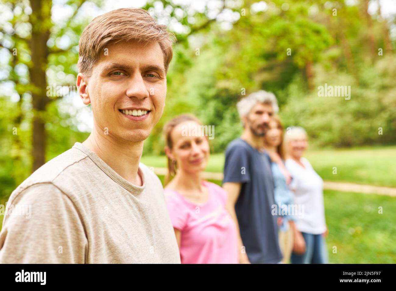 Young man as a student with friends on a trip in nature in summer Stock Photo