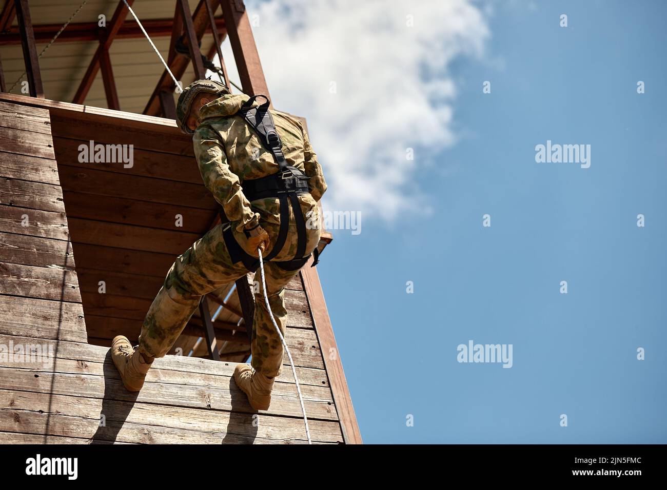 Military soldier climbing net during obstacle course in boot camp Stock Photo
