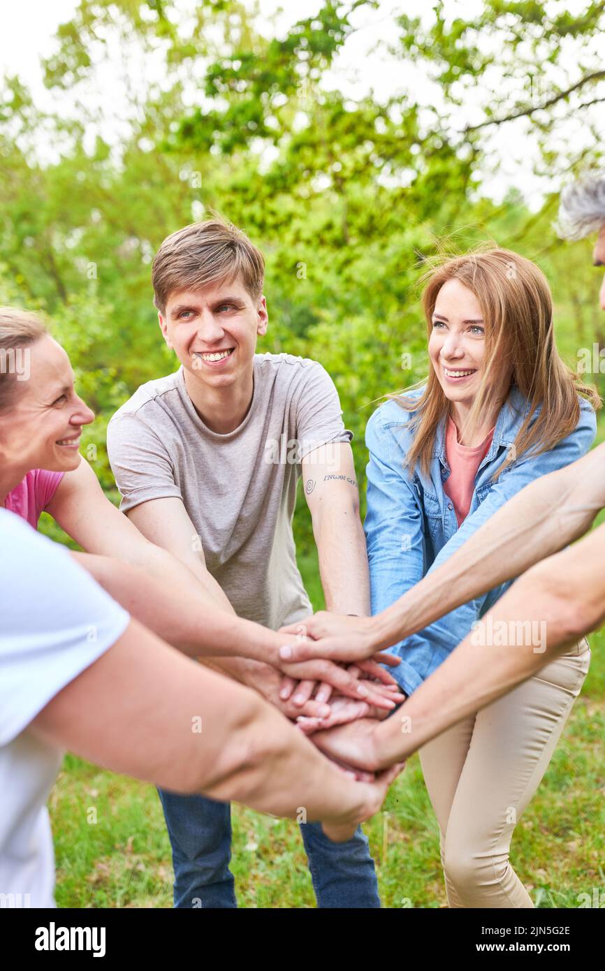 Young team stacking hands as an exercise for motivation and team spirit in nature Stock Photo