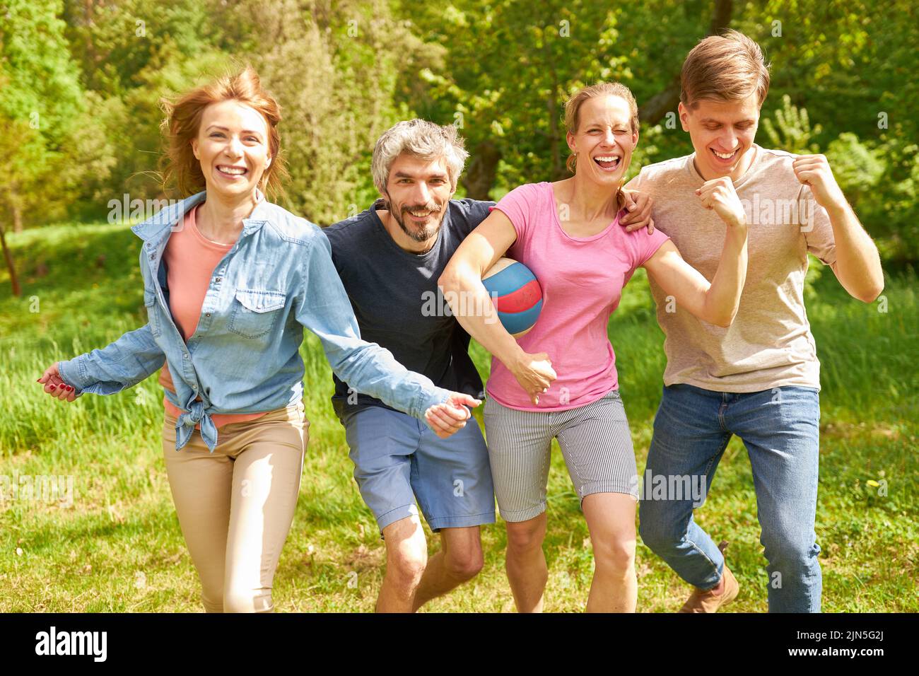 Young people as a successful team with football and clenched fists for motivation Stock Photo