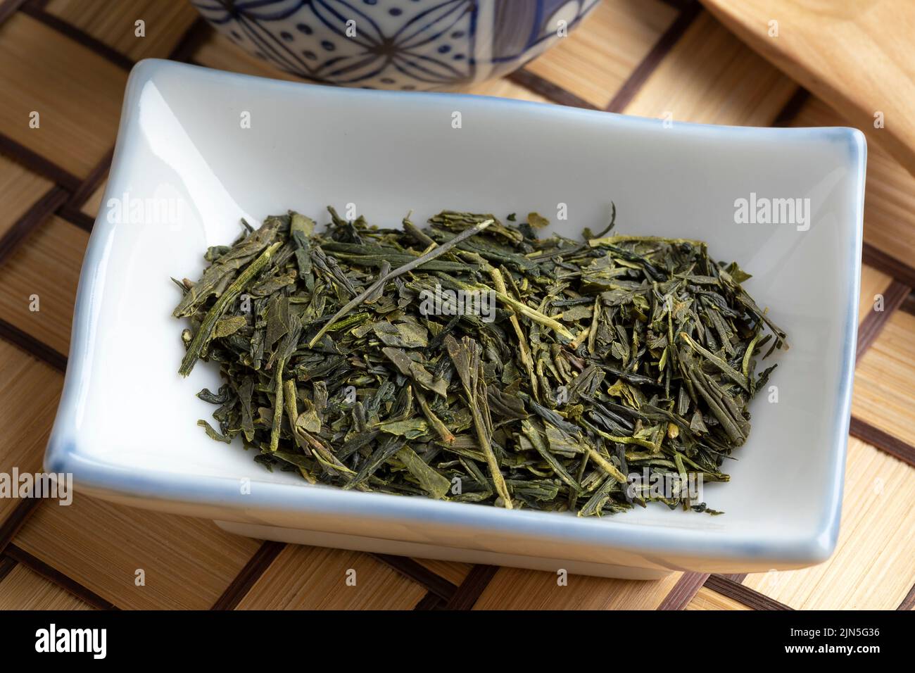 Bowl with Sencha Superior green dried tea leaves close up Stock Photo