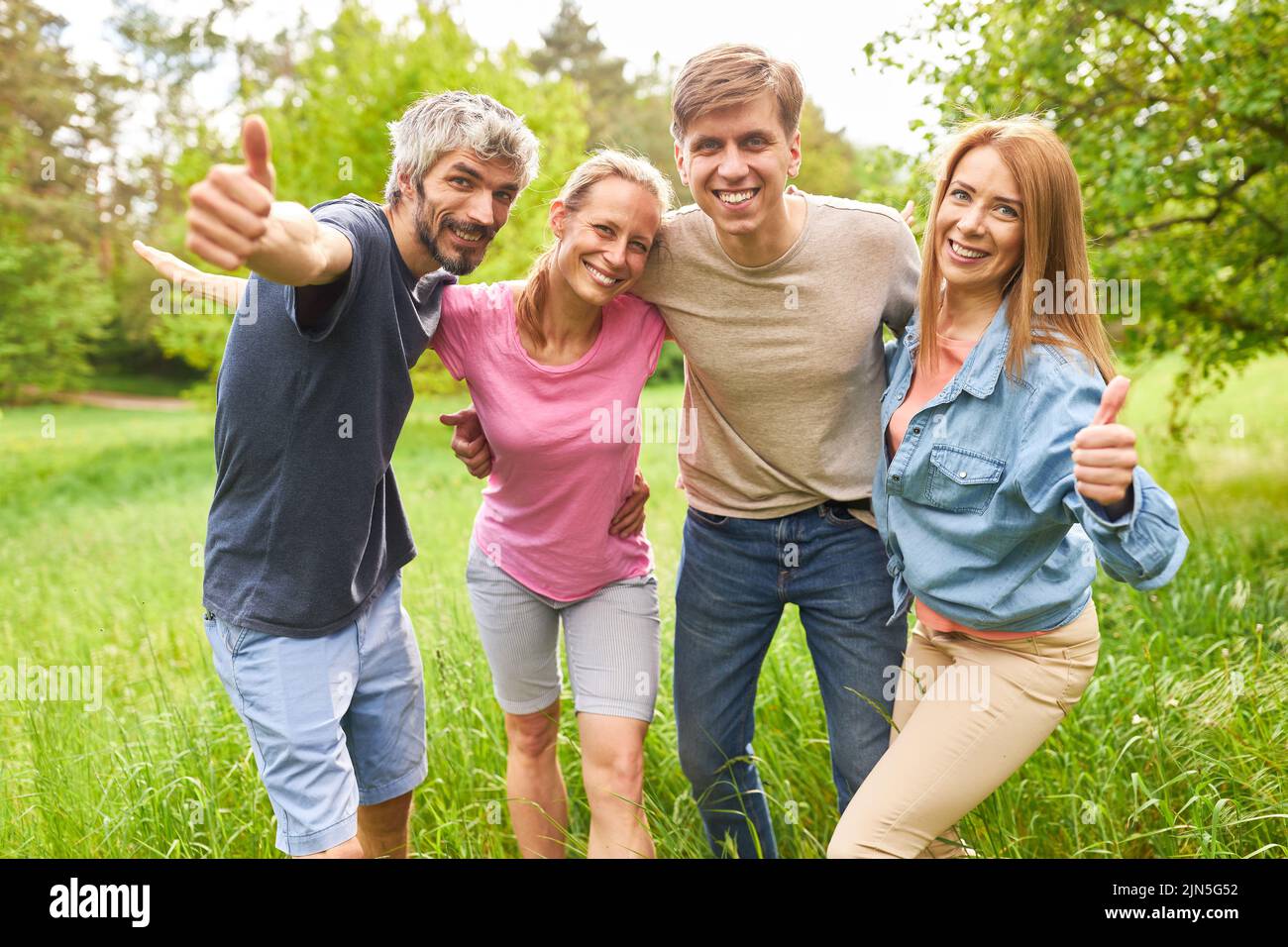 Group of young people as friends showing thumbs up for optimism and community Stock Photo