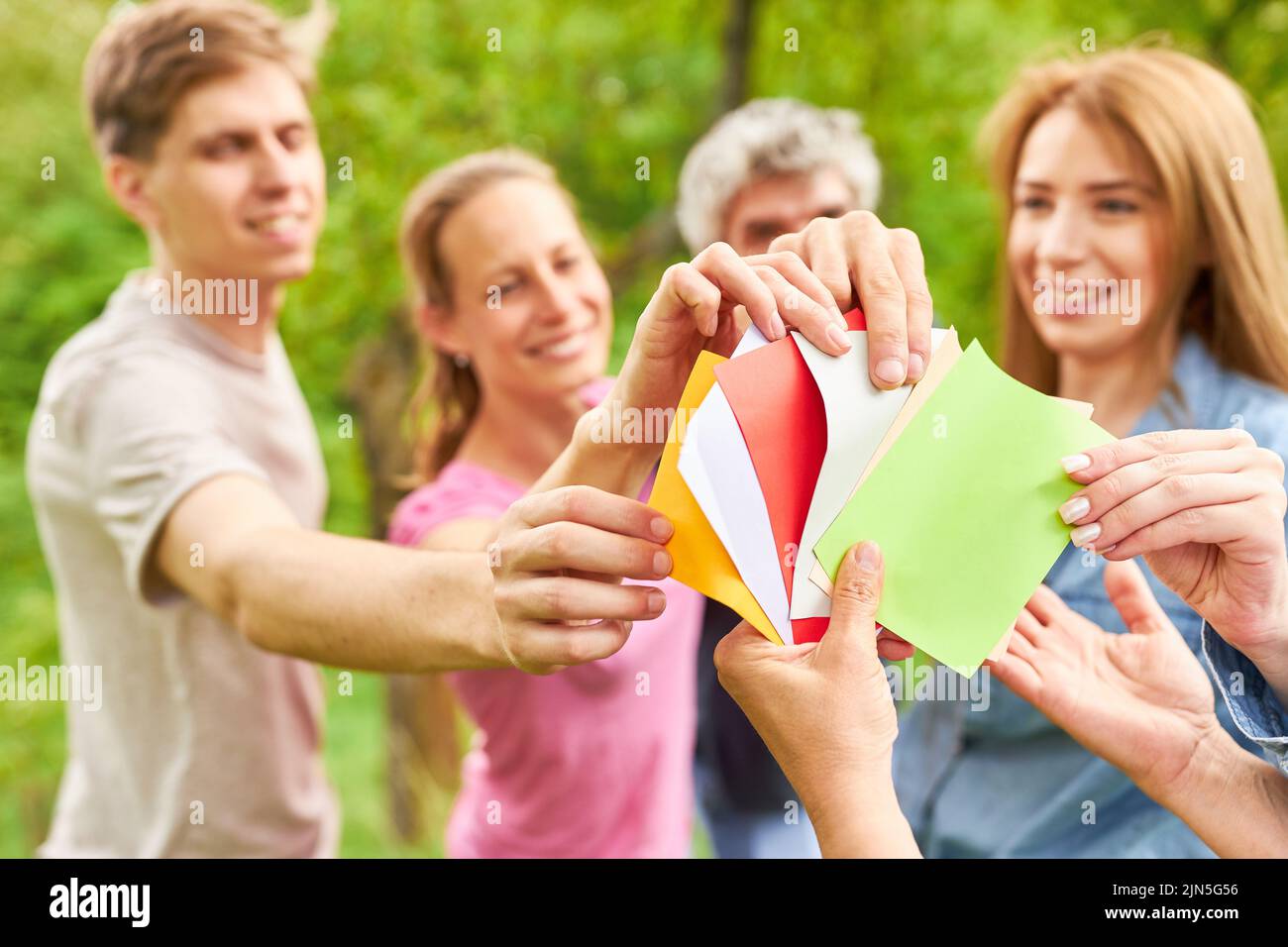 Team of young people draw cards at the team building game to get to
