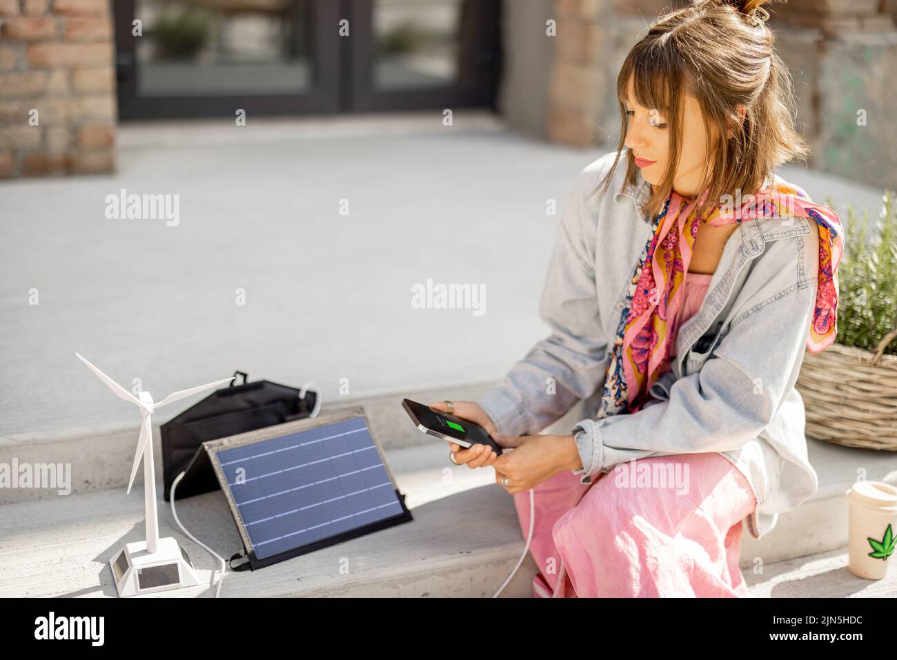 Woman charge phone from a portable solar panel Stock Photo Alamy
