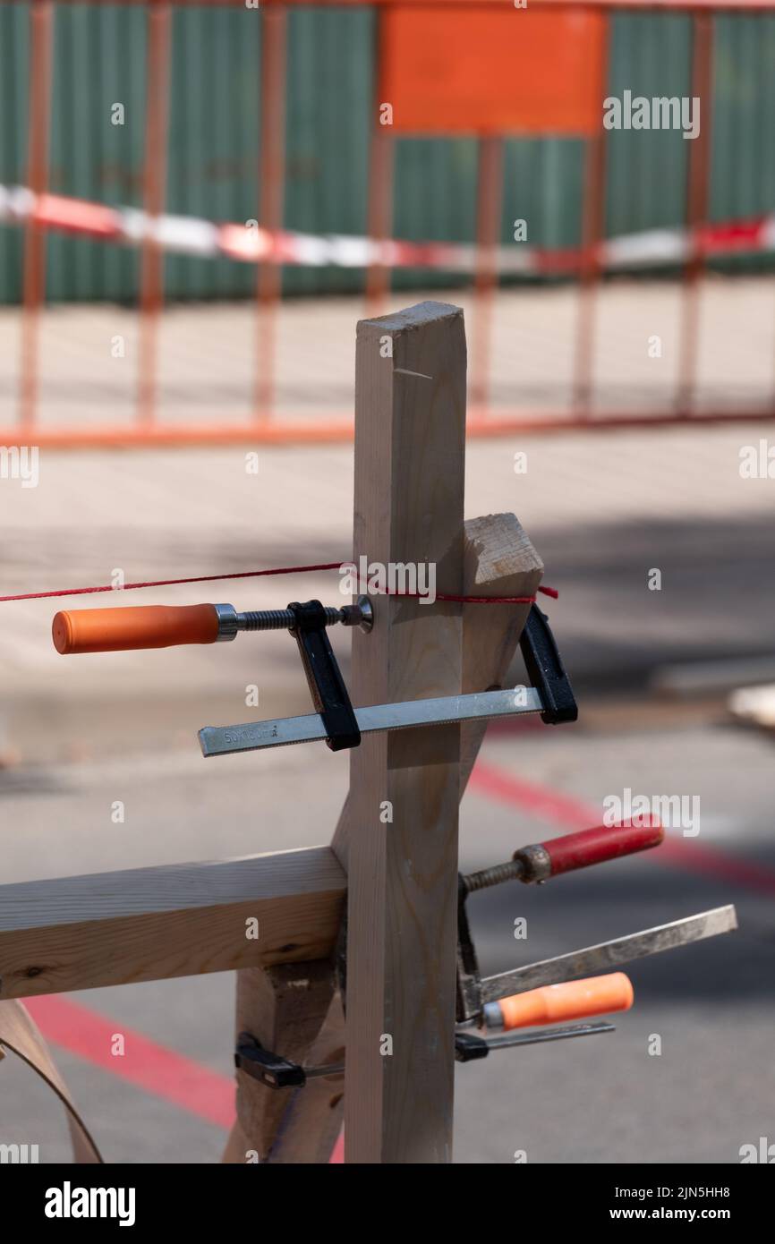 Three carpenter's clamps on two pieces of wood together to form the