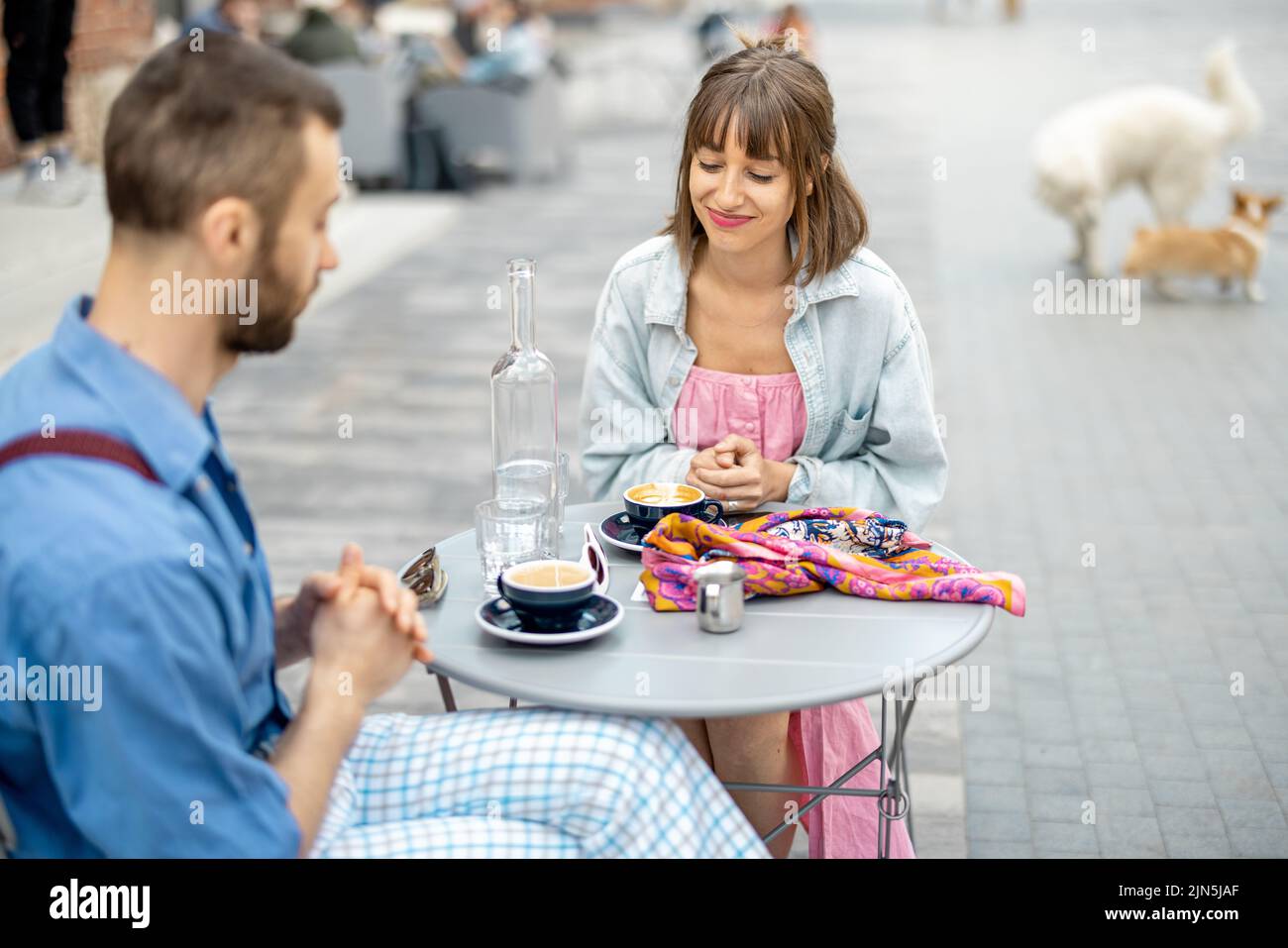 Stylish woman talks with her male colleague at cafe Stock Photo