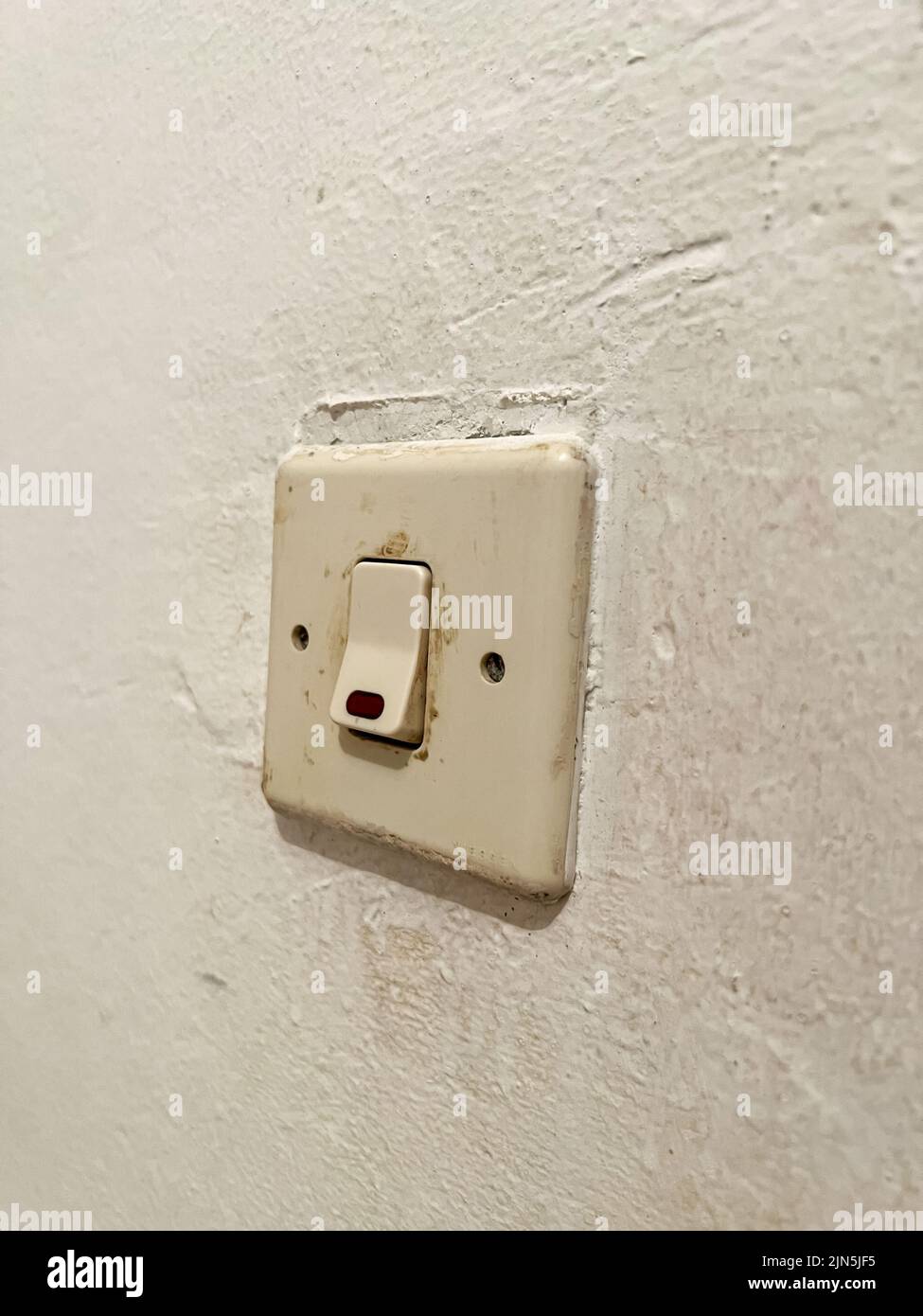 An old fashioned light switch mounted on a white wall Stock Photo Alamy