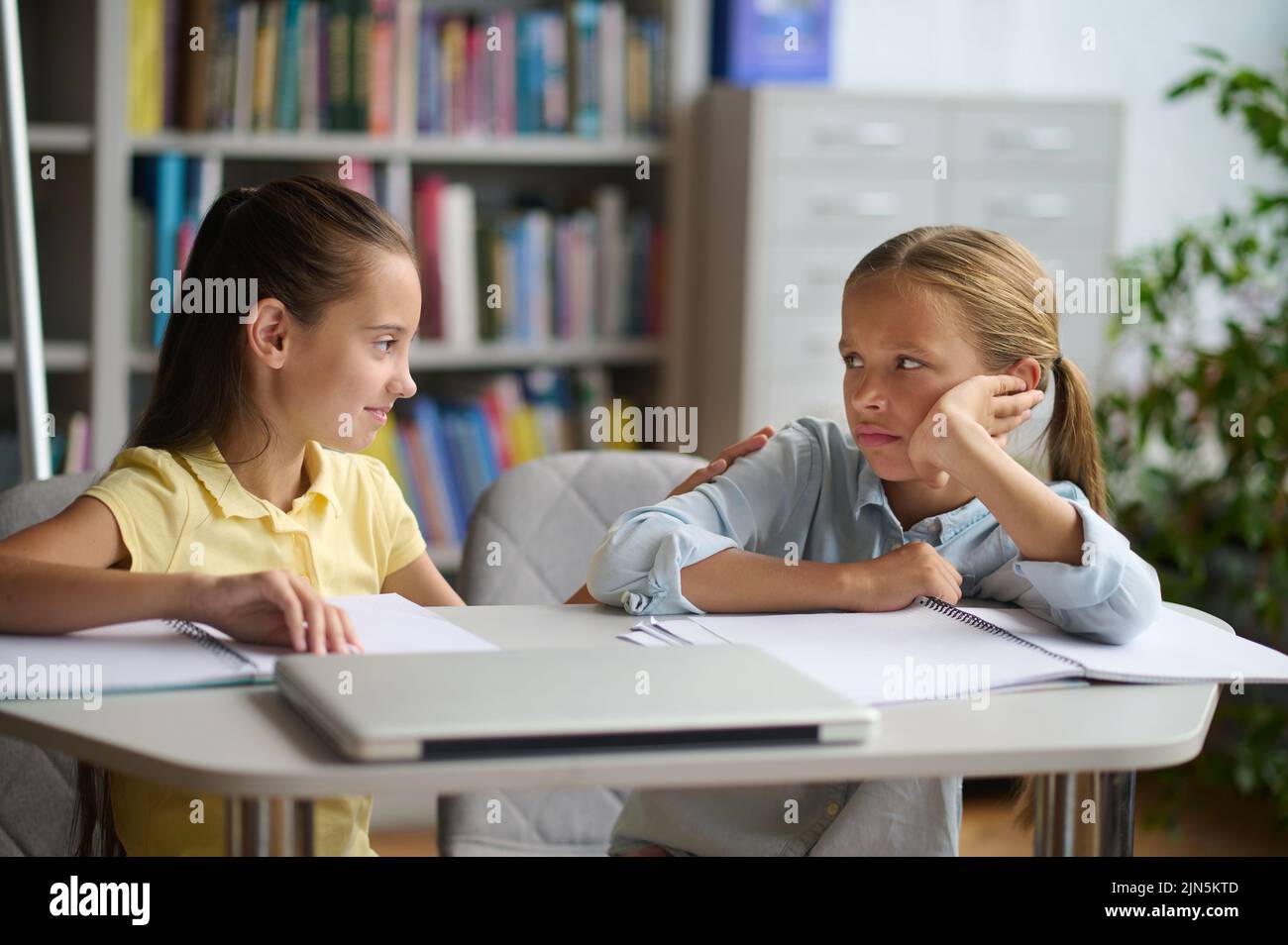 Caring teenage girl comforting her sad friend in the reading room Stock ...