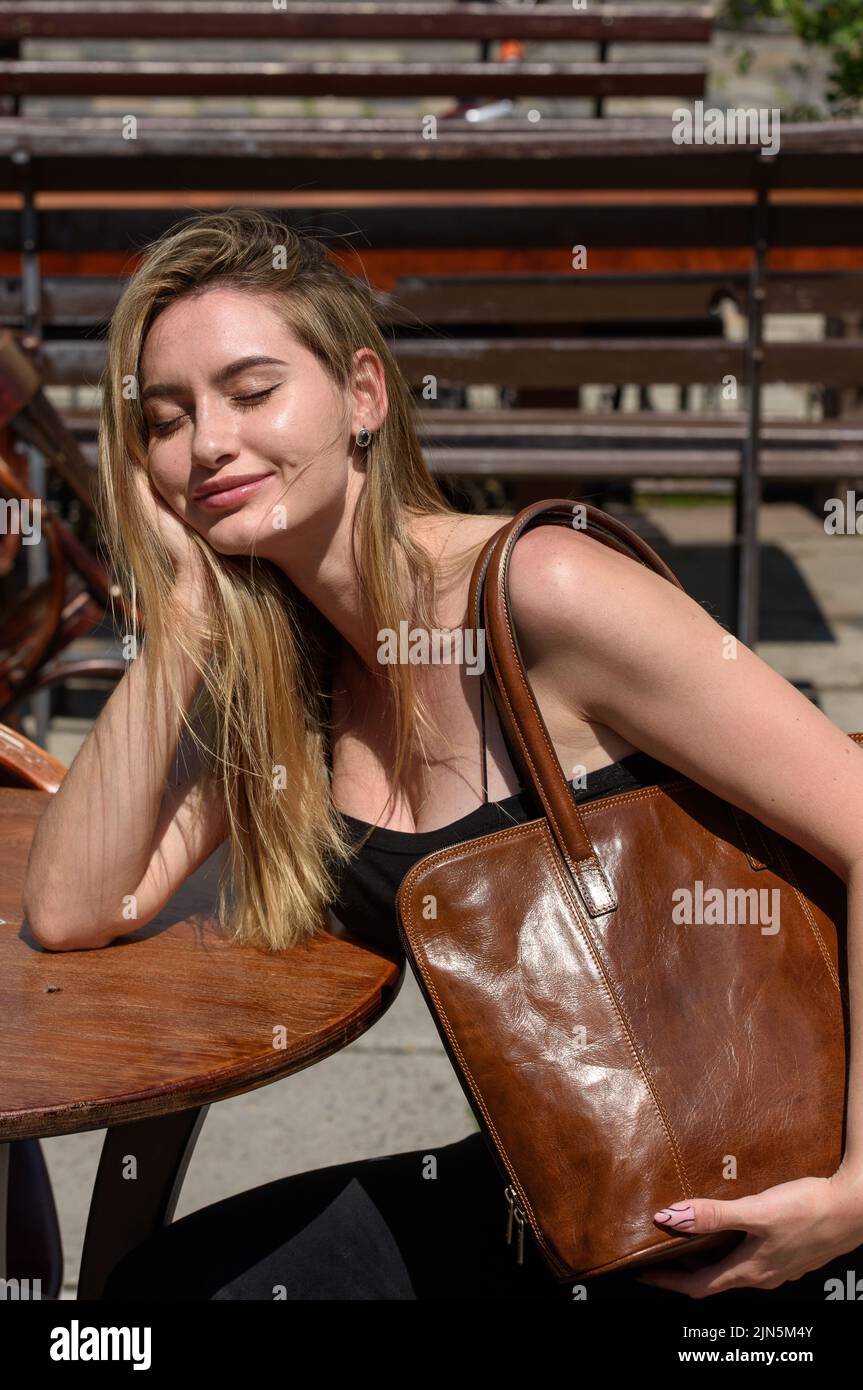 close-up photo of brown leather bag in a hands of a beautiful woman Stock Photo