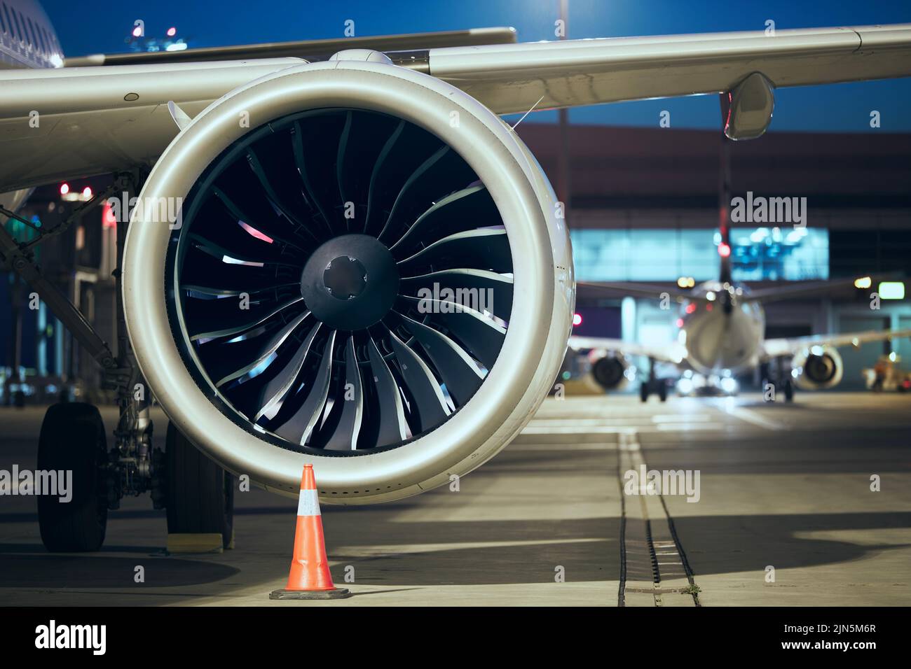 Close-up of jet engine of plane at airport. Preparation of airplane before night flight. Stock Photo