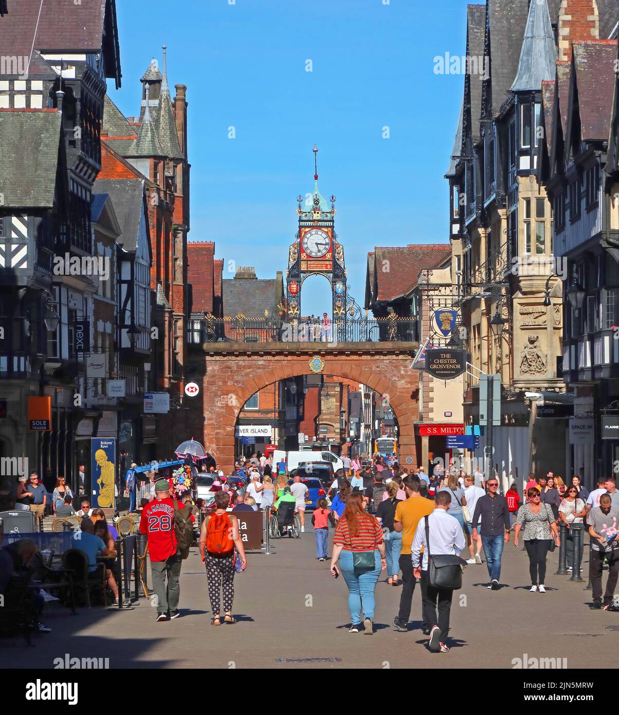 A busy summers day, at Eastgate showing Victorian 1897 Turret Clock and city walls Georgian arch bridge, Chester, Cheshire, England, UK, CH1 1LE Stock Photo