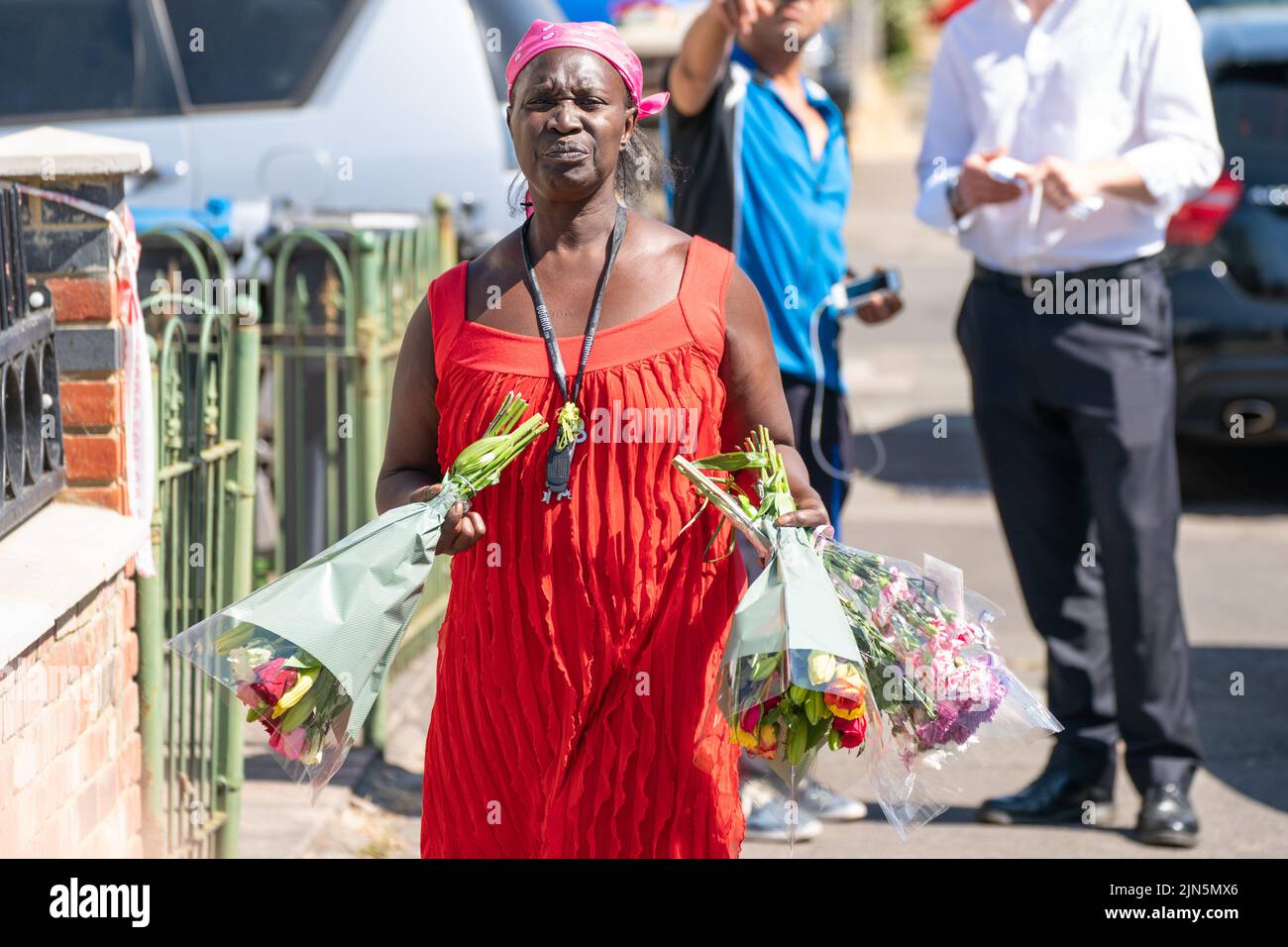 A woman arrives to lay flowers near Galpin's Road in Thornton Heath, south London. The London Ambulance Service has confirmed a child has died and three people are in hospital after the terraced home collapsed following an explosion and fire on Monday. Picture date: Tuesday August 9, 2022. Stock Photo