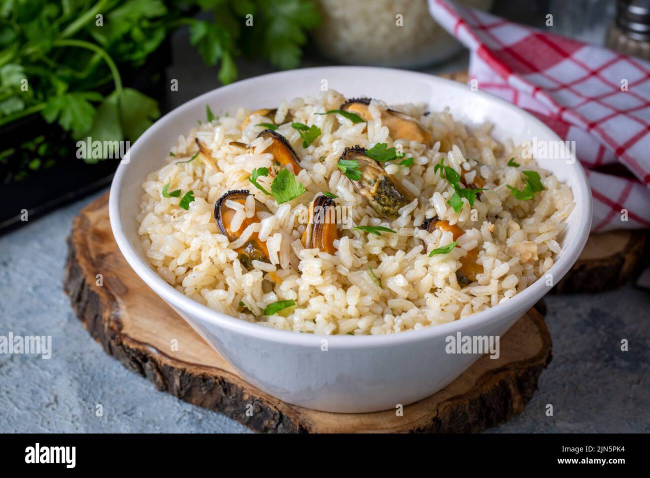 Mussel rice pilaf. Rice with mussels on small white plate on ceramic