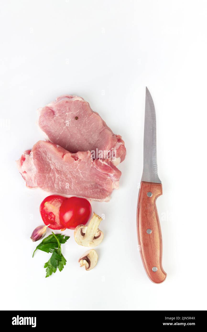 Pieces of raw beef steaks with knife, spice and pepper. Cooking concept Stock Photo