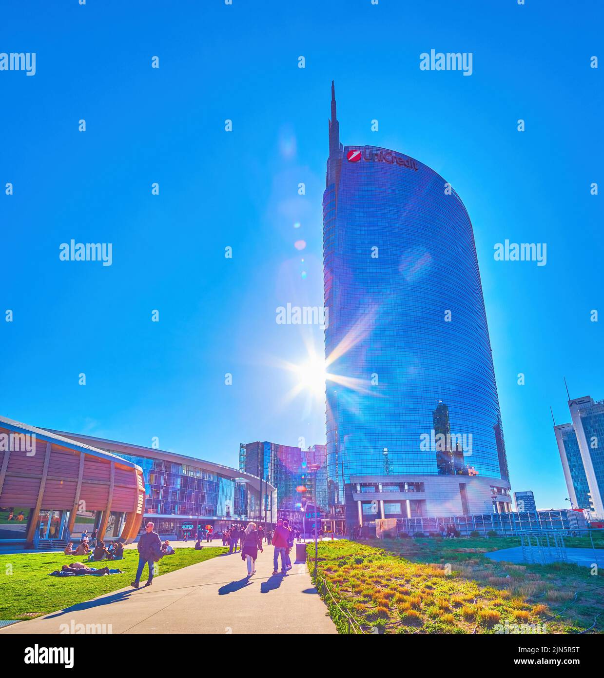 MILAN, ITALY - APRIL 9, 2022: Enjoy pleasant evening hours among modern buildings of Piazza Gae Aulenti complex, on April 9 in Milan, Italy Stock Photo