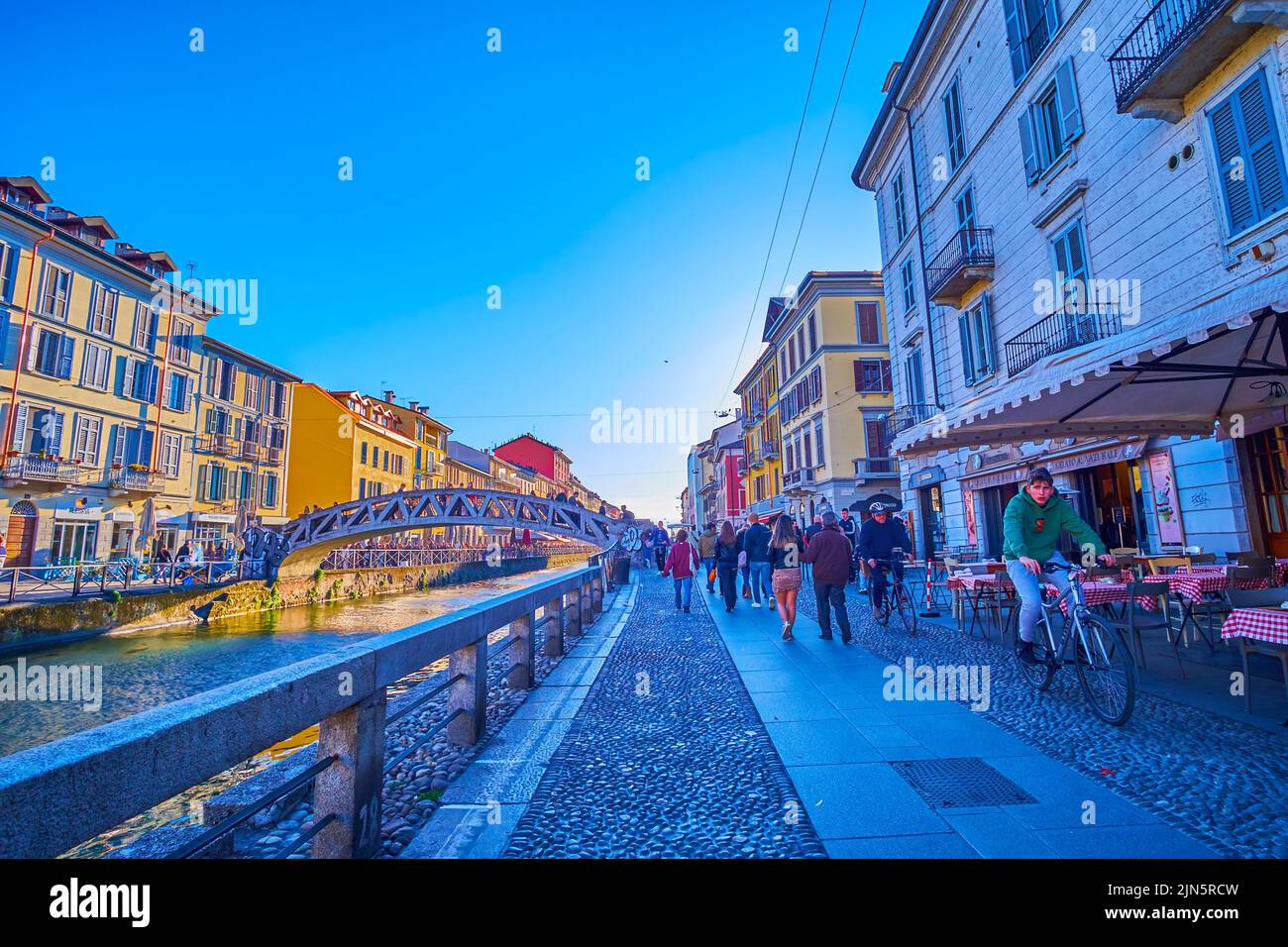 MILAN, ITALY - APRIL 9, 2022: Walk along Naviglio Grande Canal, the popular leisure place among locals, on April 9 in Milan, Italy Stock Photo