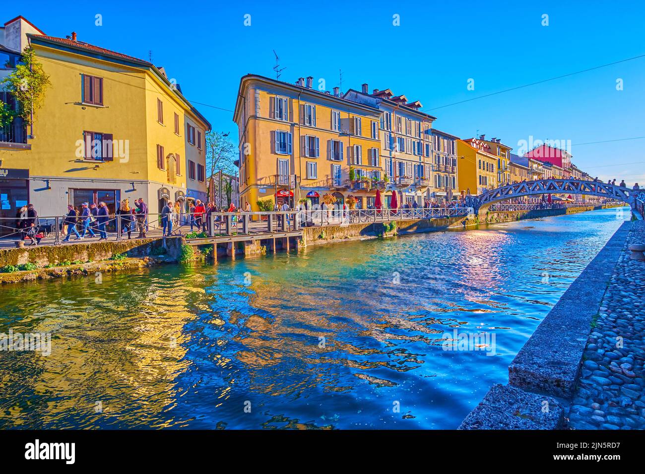 MILAN, ITALY - APRIL 9, 2022: Naviglio Grande Canal with historical houses become one of popular spots of nightlife, on April 9 in Milan, Italy Stock Photo