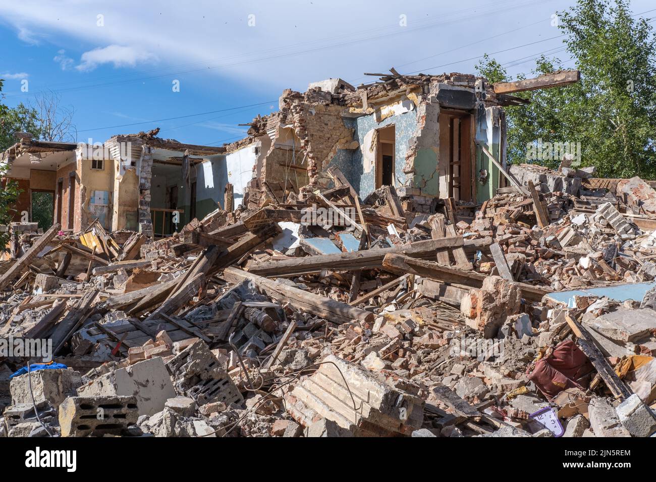 An abandoned house collapses. The house is destroyed. Cracks in wall of