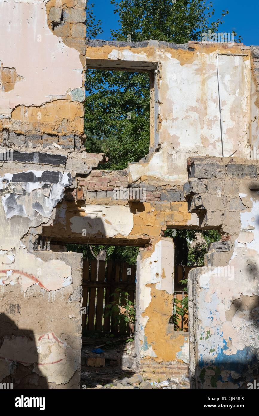 An abandoned house collapses. The house is destroyed. Cracks in wall of