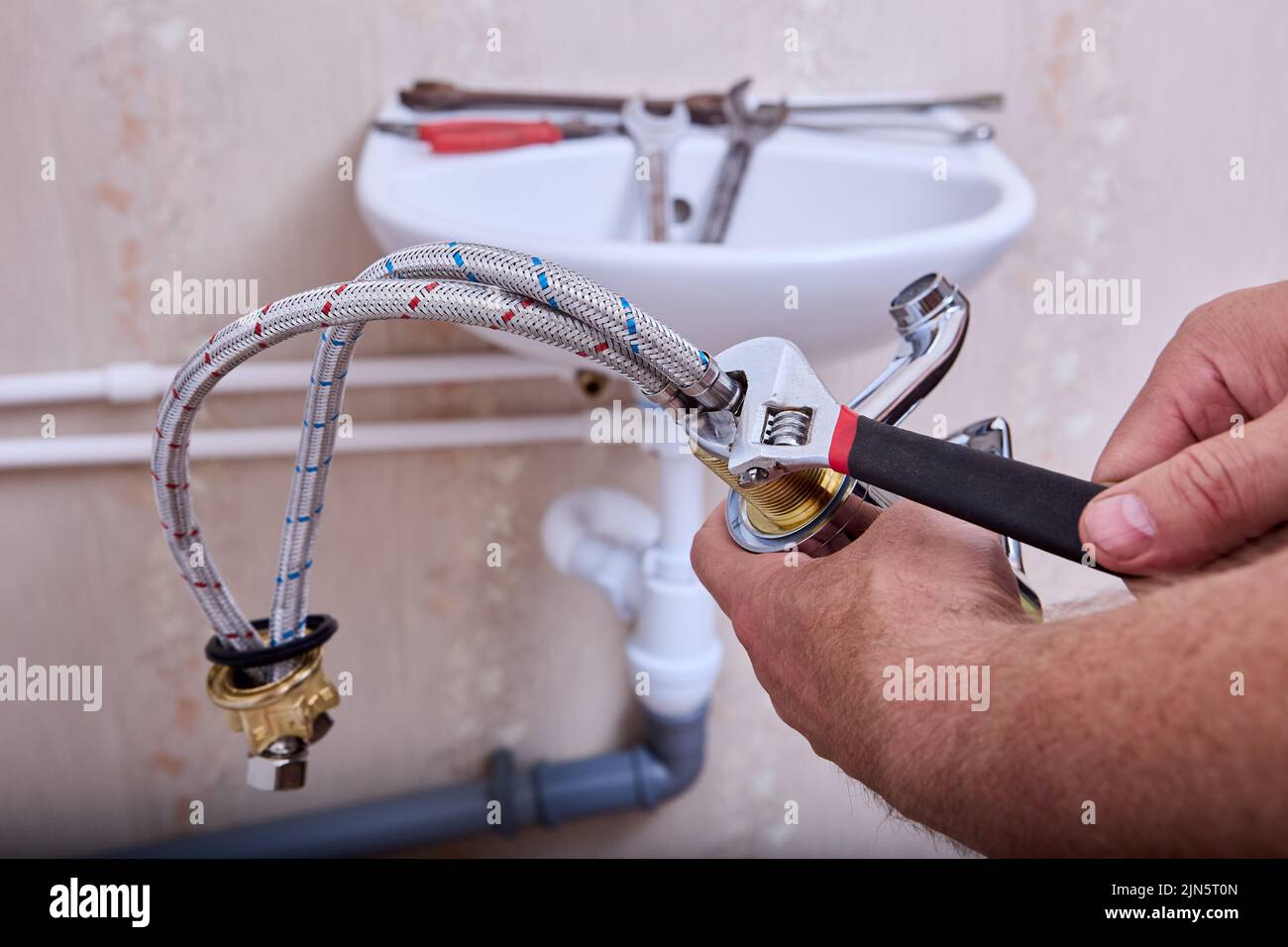 Plumbing work in toilet room, plumber installs new water faucet in home