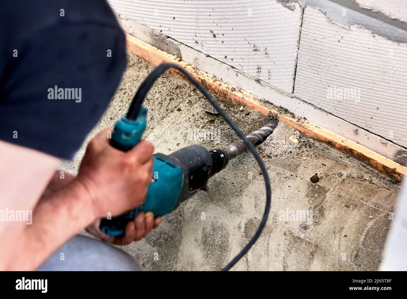 An electric rock drill at construction site is used to drill hole in ...
