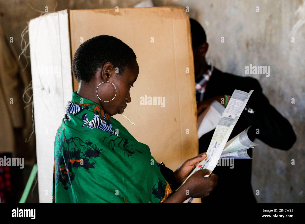 A Maasai traditional woman waits near a voting booth at a polling centre before casting her ballot during the general election by the Independent Electoral and Boundaries Commission (IEBC) at Ewaso Kedong primary school, in Kajiado county, Kenya August 9, 2022. REUTERS/Thomas Mukoya Stock Photo