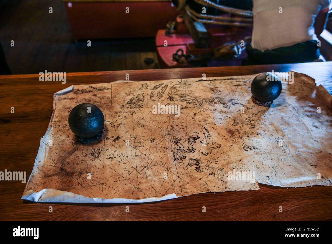 London UK 9 August 2022 Two cannon balls used as paper weight for an old map on  one the table were the crew, eat  and sleep in hammoks Open to visitors every day until 12 of August  Paul Quezada-Neiman/Alamy Live News Stock Photo