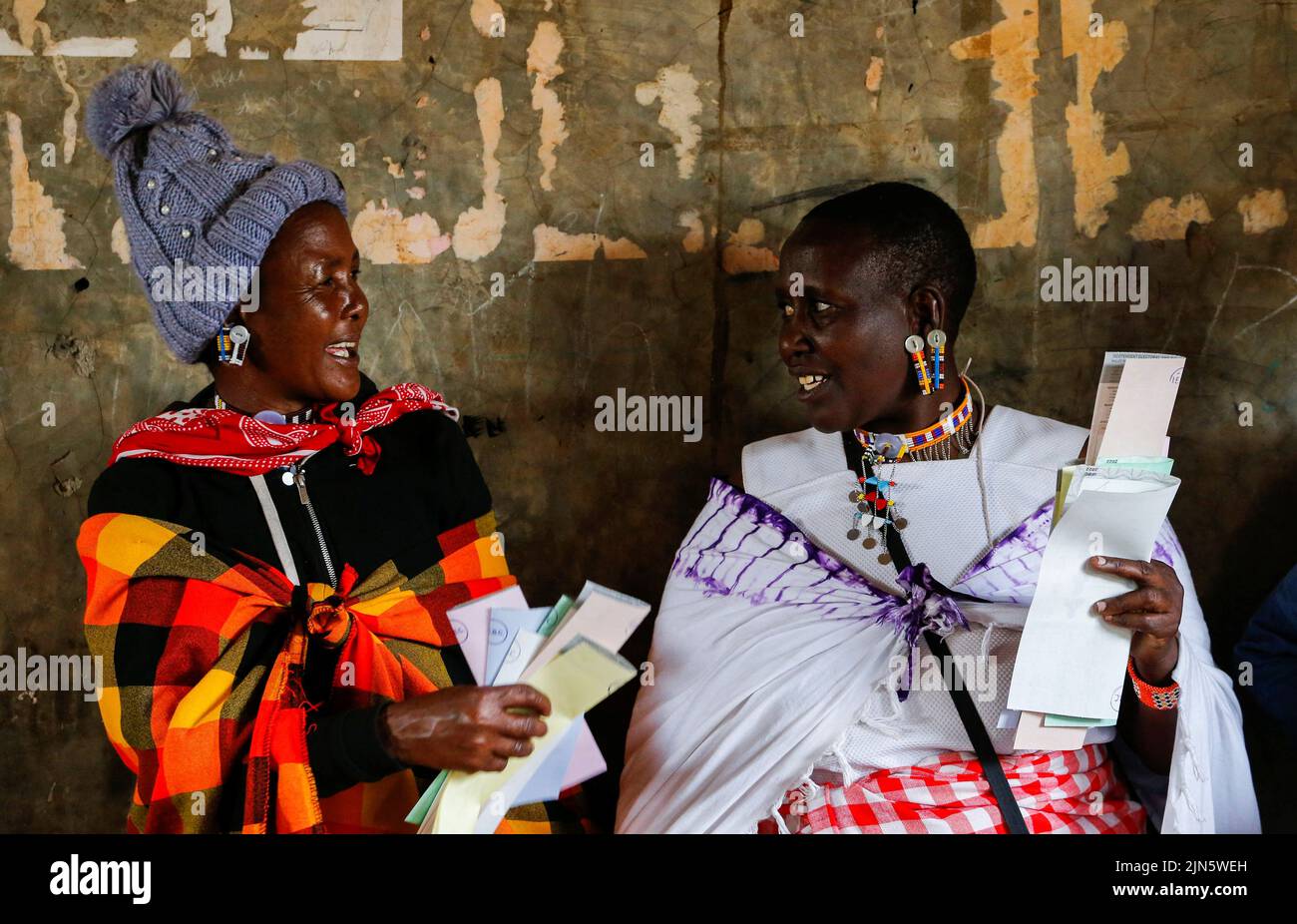 Maasai traditional women talk near a voting booth at a polling centre before casting their ballots during the general election by the Independent Electoral and Boundaries Commission (IEBC) at Ewaso Kedong primary school, in Kajiado county, Kenya August 9, 2022. REUTERS/Thomas Mukoya     TPX IMAGES OF THE DAY Stock Photo