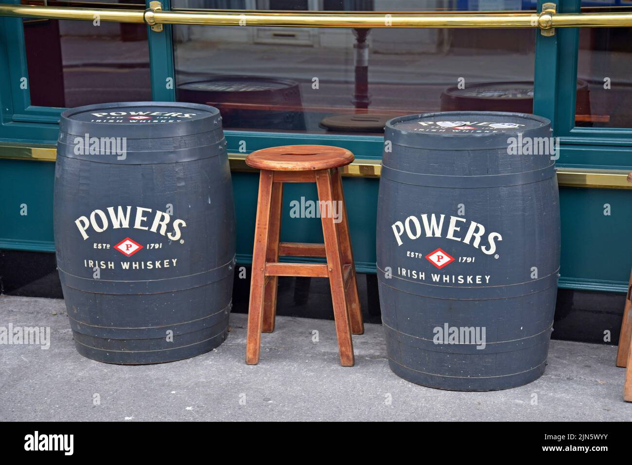 Wooden Powers Irish whiskey barrels serving as tables outside a