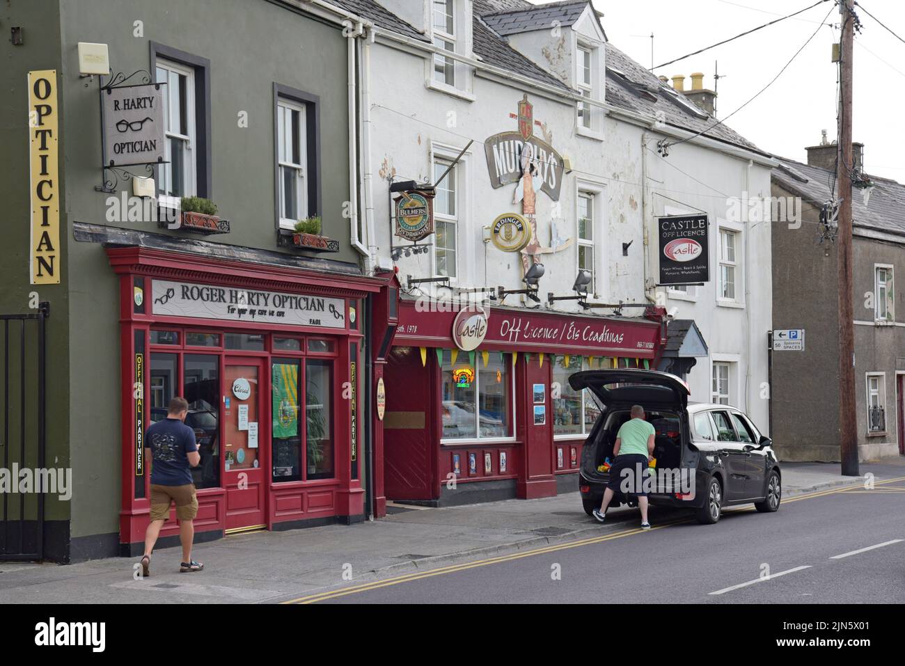 A man loads a car outside the Castle Off Licence, formerly a traditional Irish pub, in Tralee, County Kerry, Ireland Stock Photo