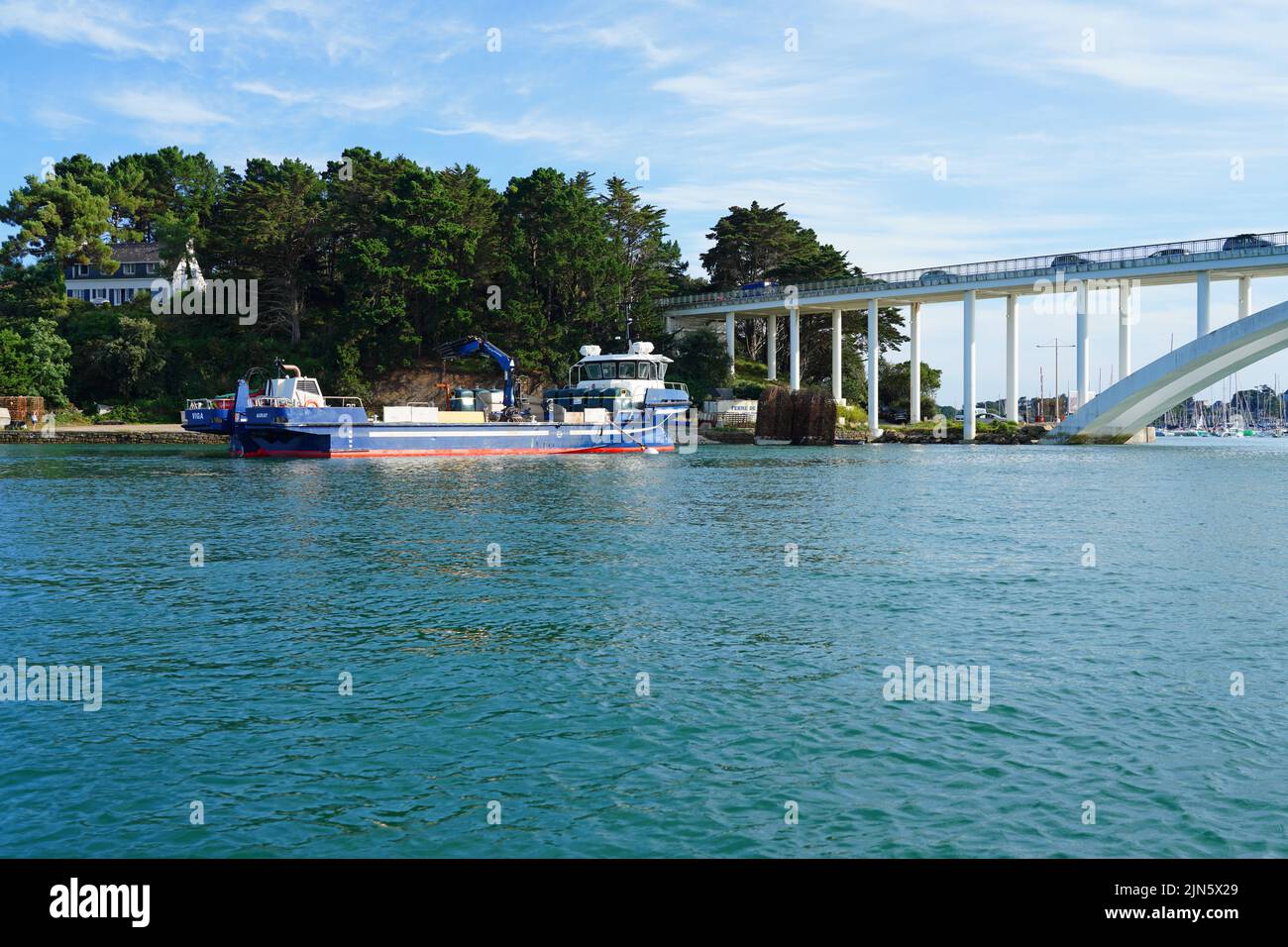 LA-TRINITE-SUR-MER, FRANCE -12 AUG 2021- View of the Pont de Kerisper bridge over the harbor in La Trinite sur Mer on the Bay of Quiberon in Morbihan, Stock Photo