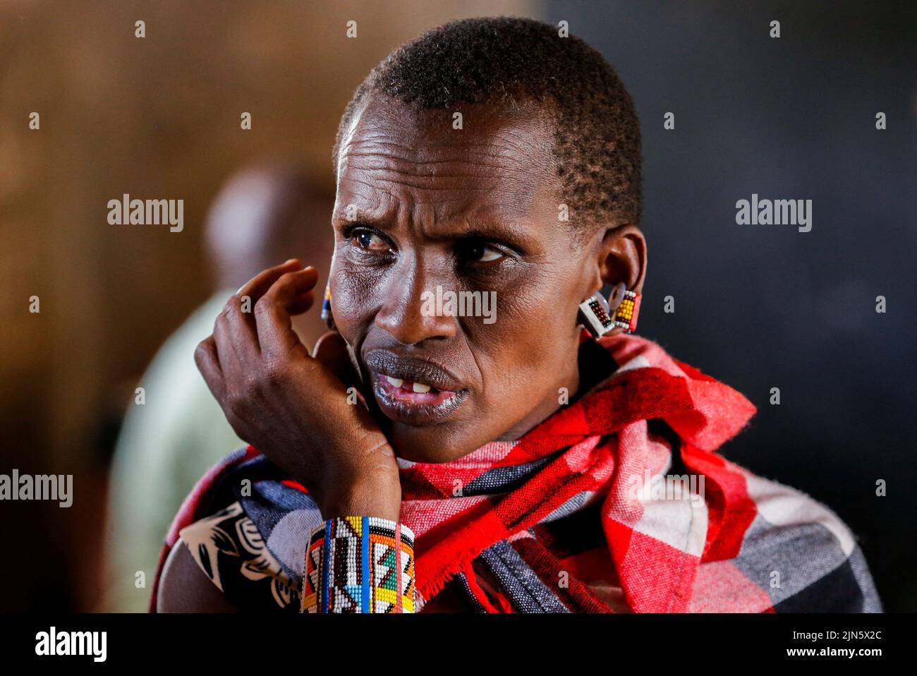 A Maasai traditional woman waits near a voting booth at a polling centre before casting her ballot during the general election by the Independent Electoral and Boundaries Commission (IEBC) in Ewaso Kedong primary school, in Kajiado county, Kenya August 9, 2022. REUTERS/Thomas Mukoya Stock Photo
