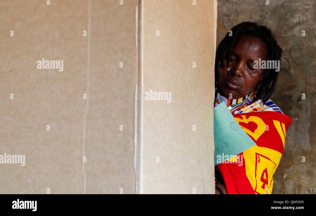 A Maasai traditional woman casts her ballot inside a voting booth at a polling centre during the general election by the Independent Electoral and Boundaries Commission (IEBC) in Ewaso Kedong primary school, in Kajiado county, Kenya August 9, 2022. REUTERS/Thomas Mukoya Stock Photo