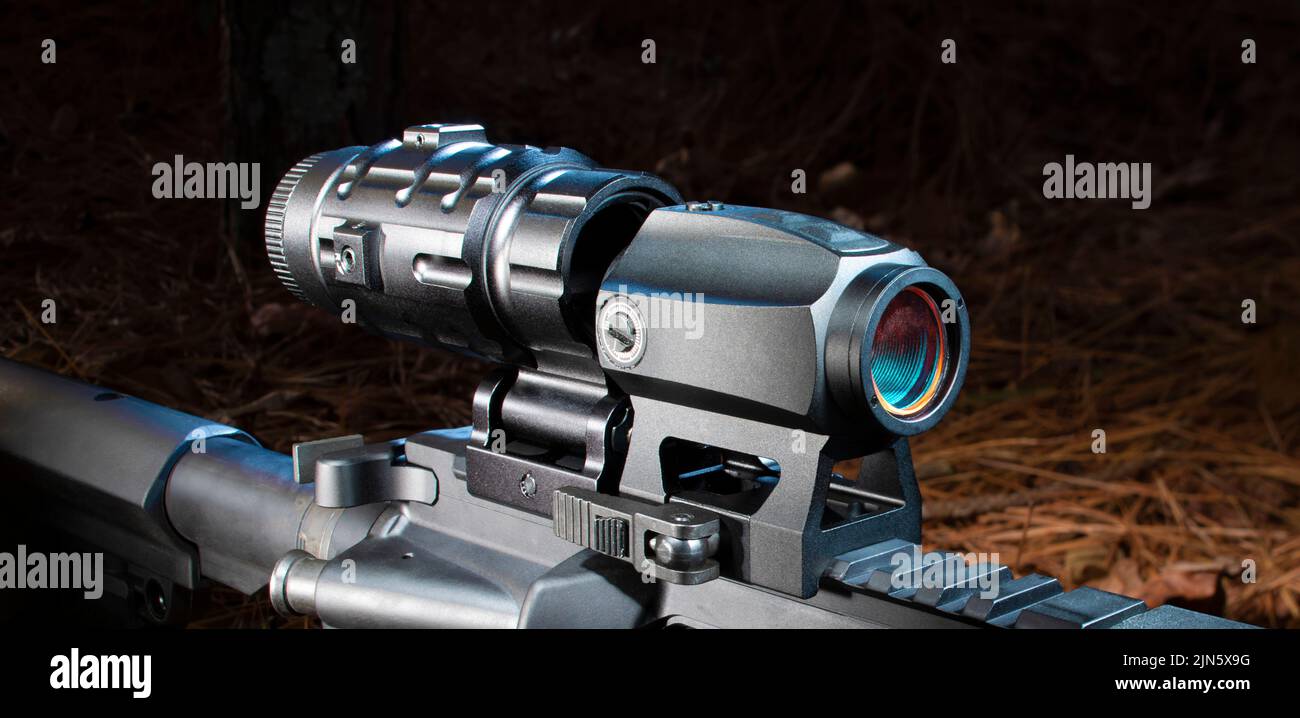 Magnifier behind a rifle'sred dot sight in the field Stock Photo