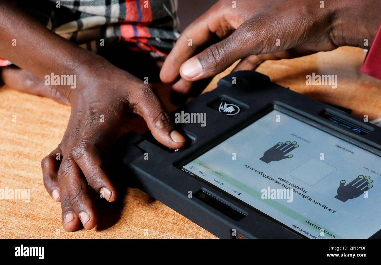 A voter uses the Kenya Integrated Election Management System (KIEMS) kit before participating in the electoral process at a polling centre by the Independent Electoral and Boundaries Commission (IEBC) in Ewaso Kedong primary school in Kajiado county, Kenya August 9, 2022. REUTERS/Thomas Mukoya Stock Photo