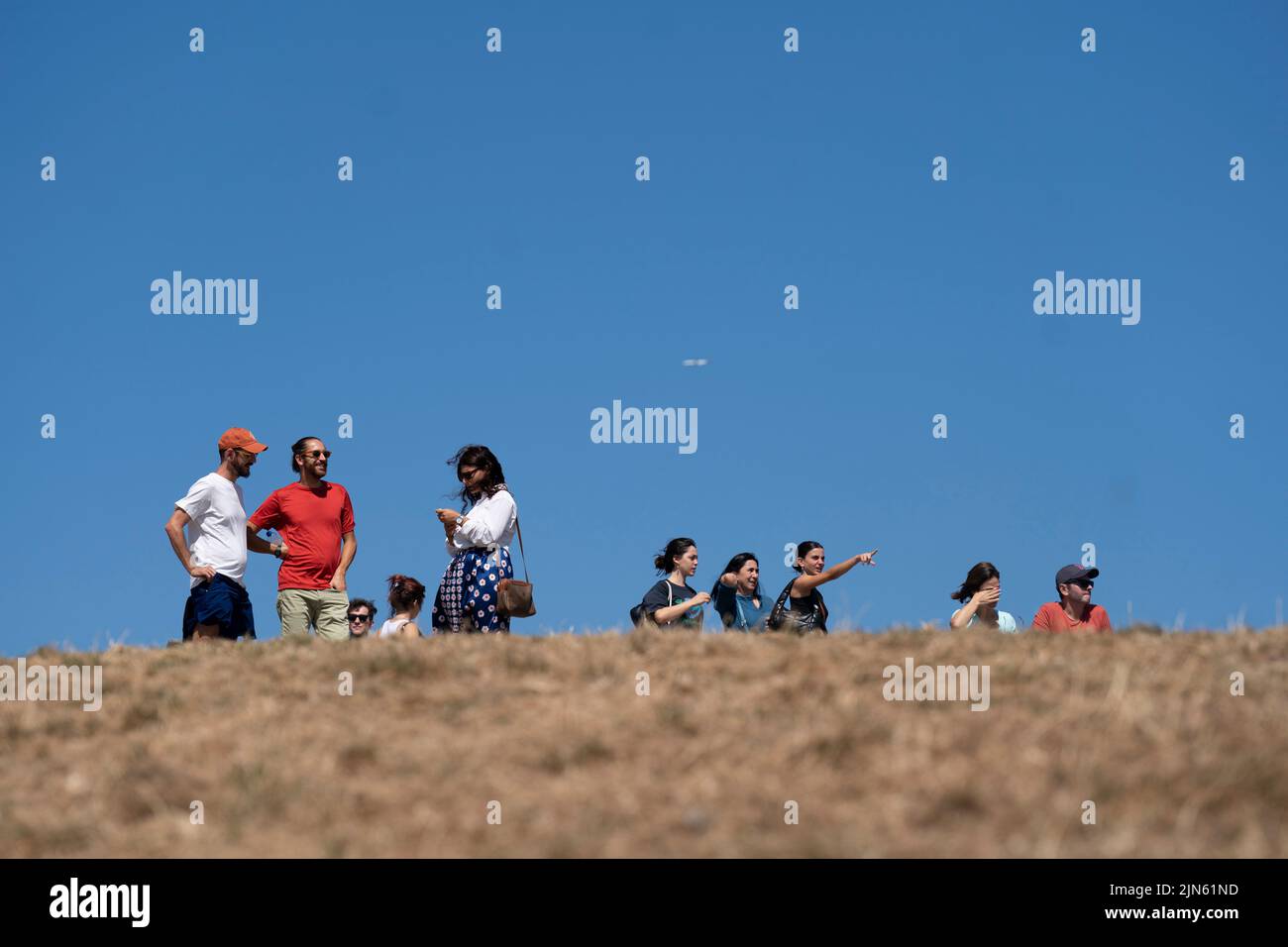 People enjoy the hot weather on Primrose Hill in London where the grass is dry due to lack of water. The Met Office has issued an amber warning for extreme heat covering four days from Thursday to Sunday for parts of England and Wales as a new heatwave looms. Picture date: Tuesday August 9, 2022. Stock Photo