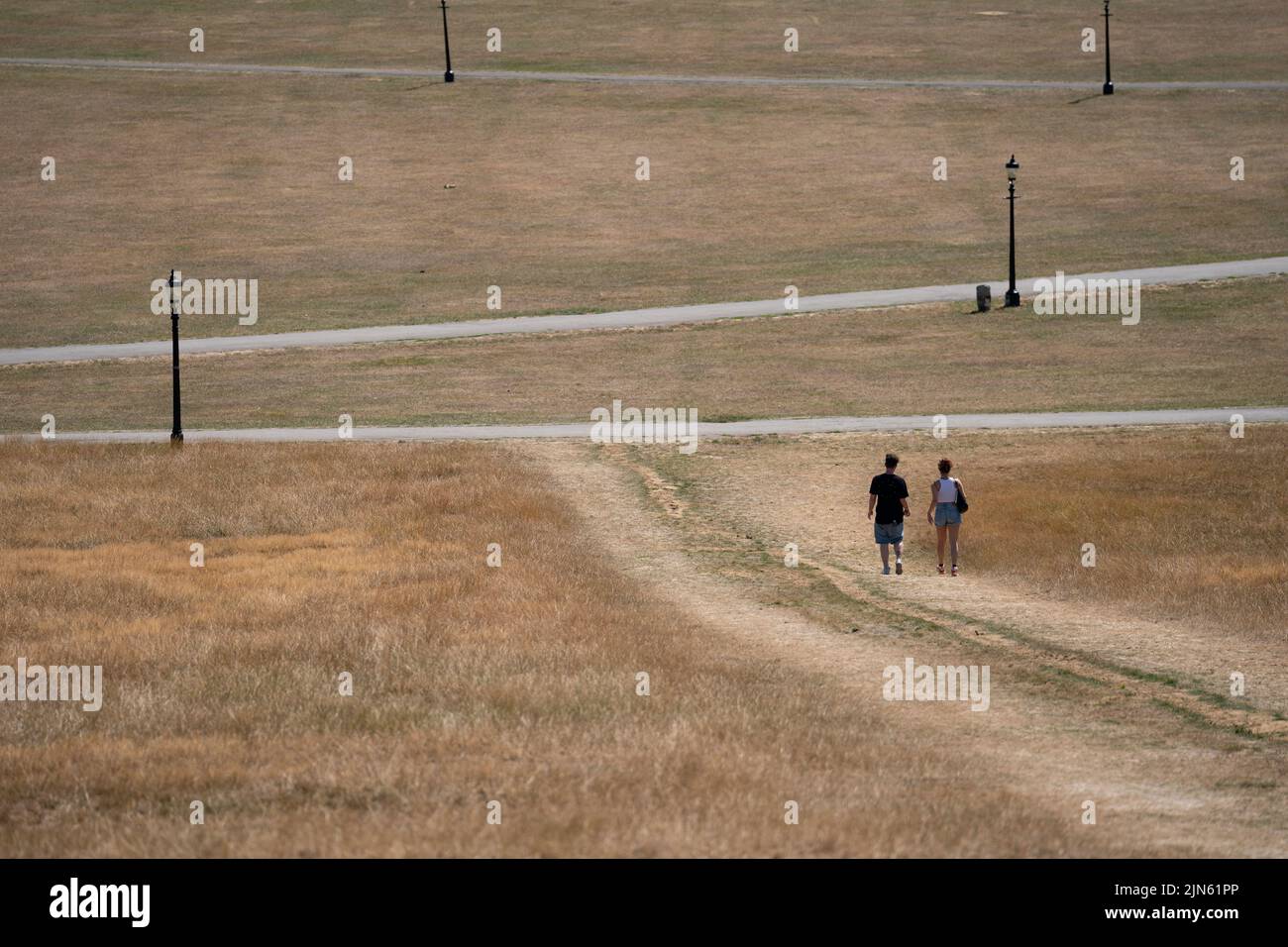 People enjoy the hot weather on Primrose Hill in London where the grass is dry due to lack of water. The Met Office has issued an amber warning for extreme heat covering four days from Thursday to Sunday for parts of England and Wales as a new heatwave looms. Picture date: Tuesday August 9, 2022. Stock Photo