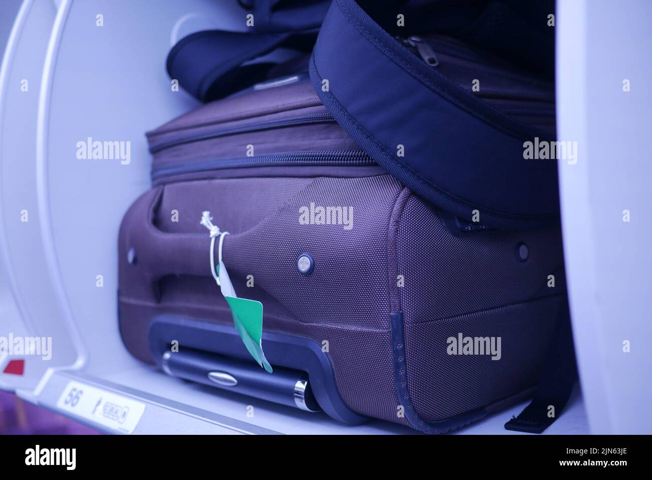suitcase in a overhead baggage area in a Airplane cabin  Stock Photo