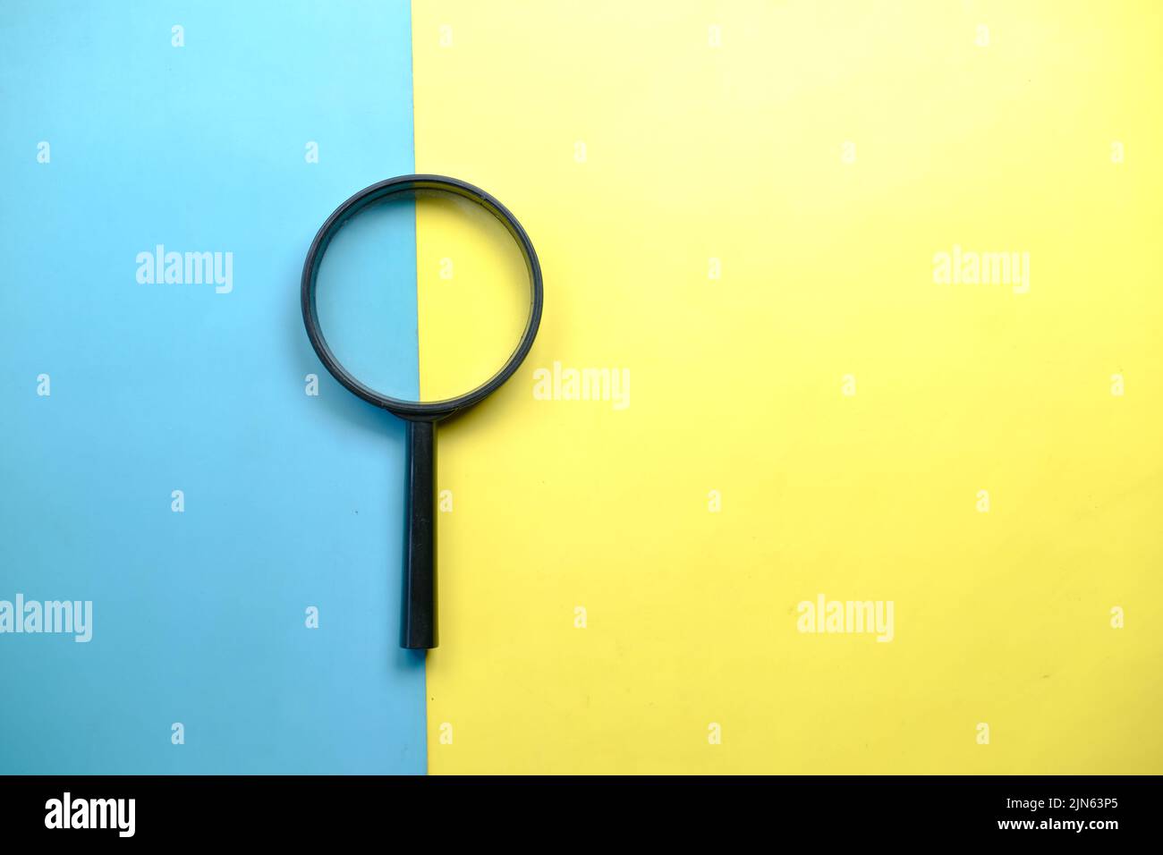a magnifying glass on color background top view  Stock Photo
