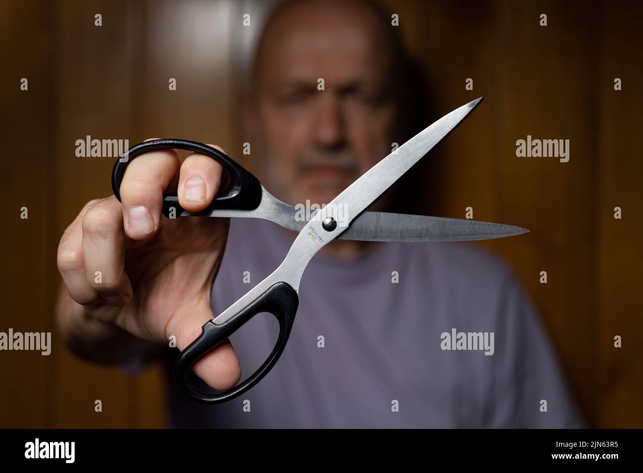 a man while making the gesture of cutting with scissors Stock Photo