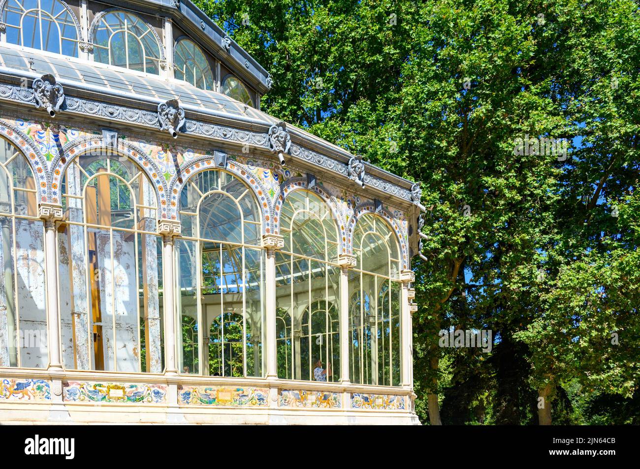 Exterior structure of the Palacio de Cristal which is located in the Parque del Buen Retiro. The building is made of glass and iron decorated with cer Stock Photo