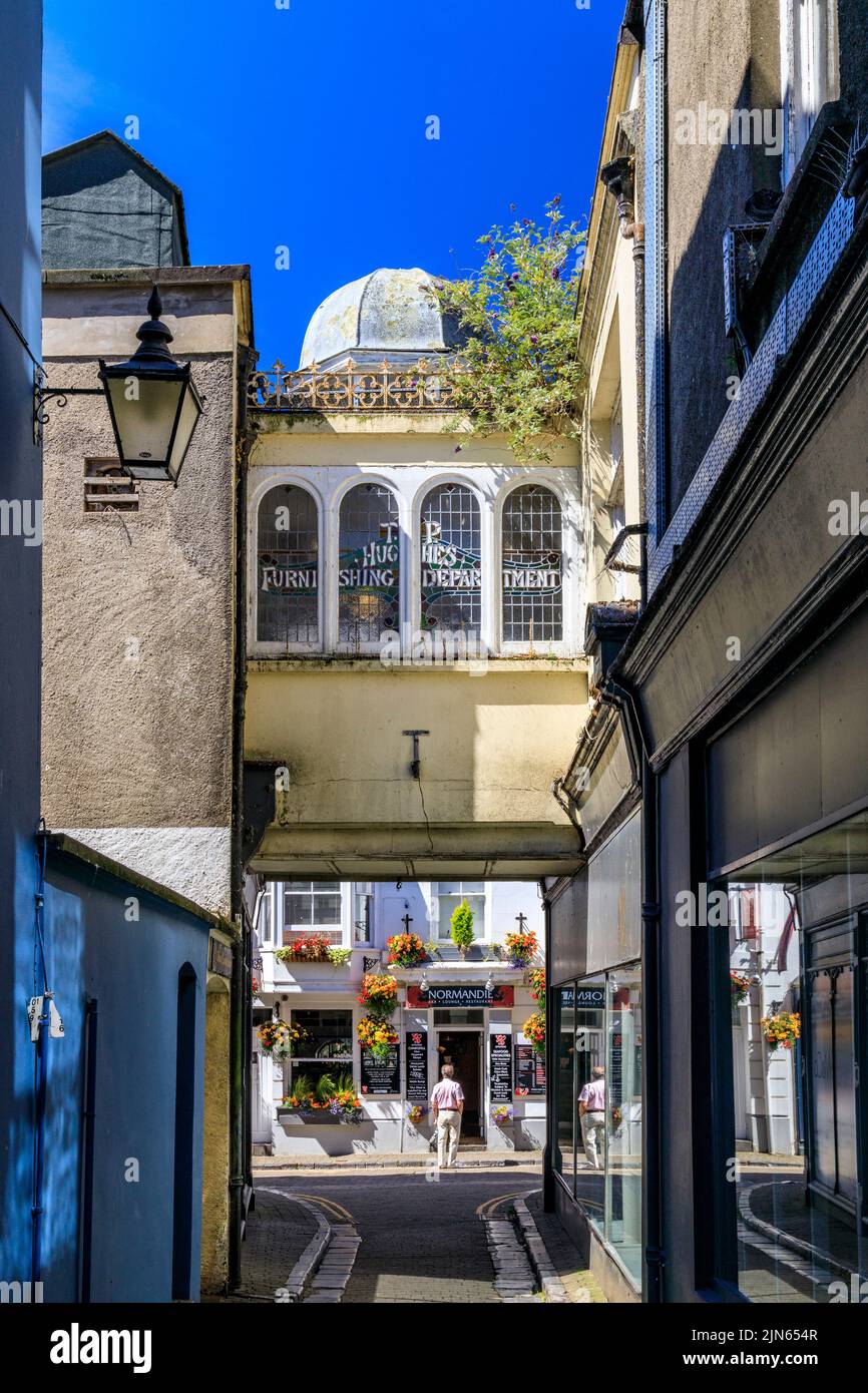 The very narrow St Nicholas Lane and colourful hanging baskets in Tenby
