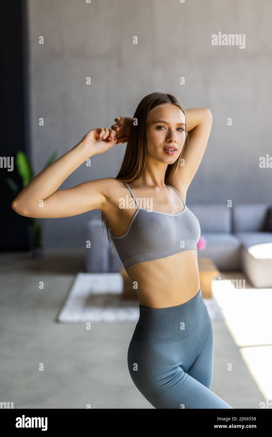 Fit woman in sportswear at home in bright room Stock Photo