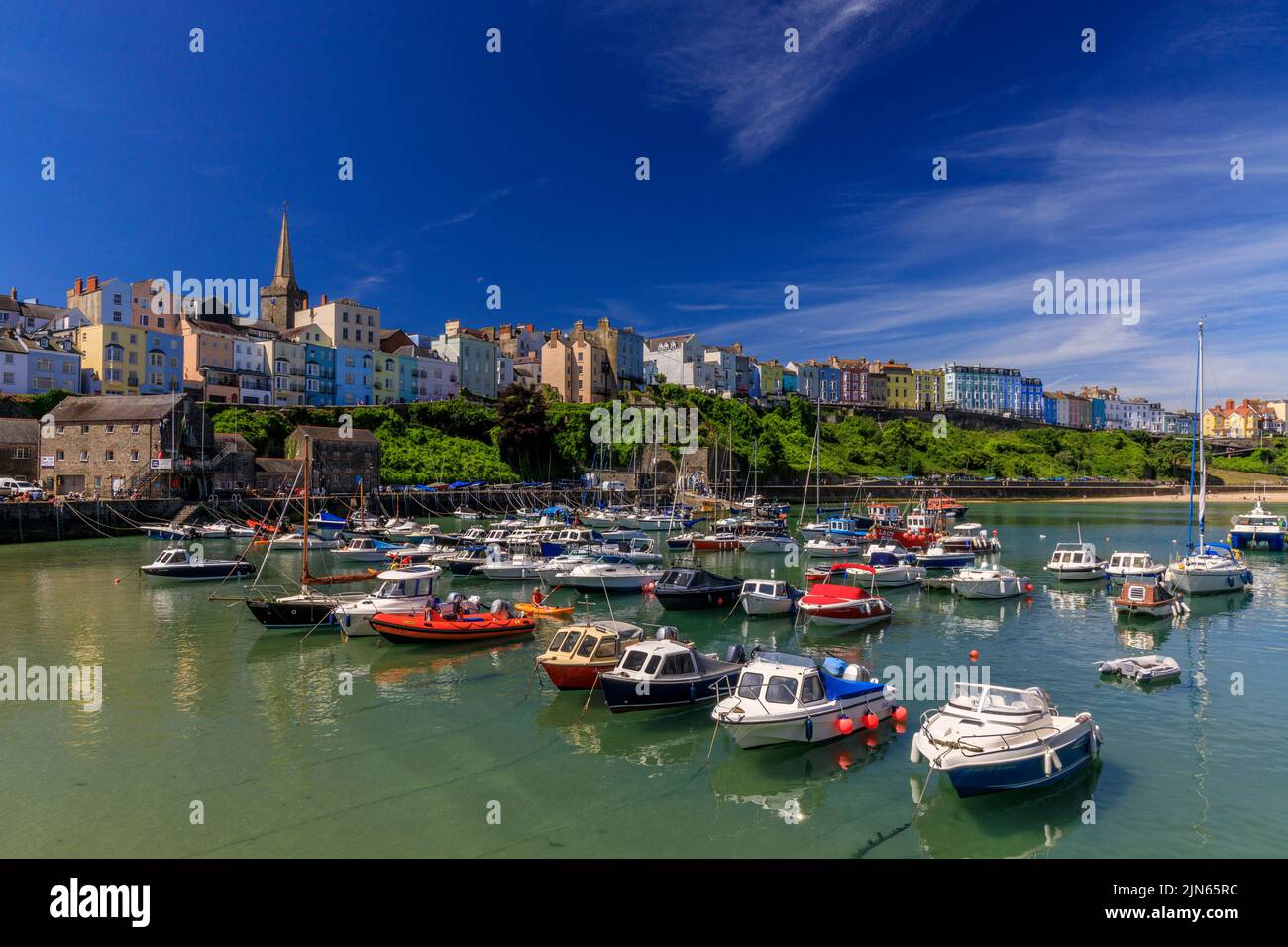 The picturesque sheltered harbour is overlooked by rows of colourful houses in Tenby, Pembrokeshire, Wales, UK Stock Photo