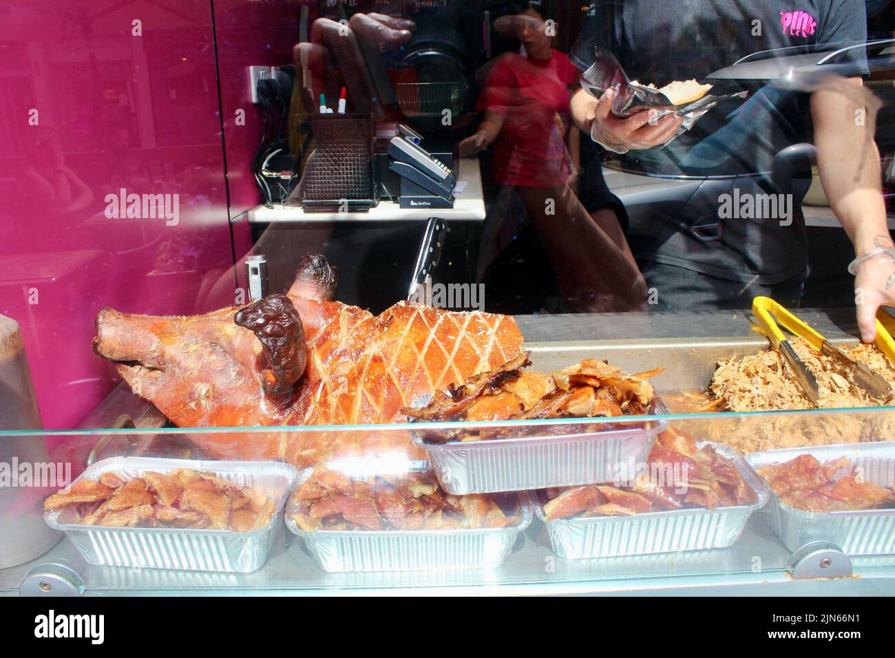 oink restaurant window with whole dead cooked pig edinburgh royal mile scotland in summer 2022 UK Stock Photo