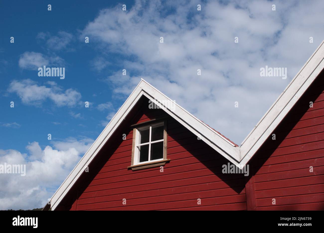 The red wooden house roof with a window against the blue sky Stock ...