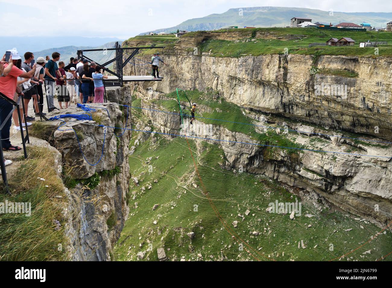 Dagestan, Russia - 21 July, 2022: Man jumps from platform above the canyon of Khunzakh and the Tobot Waterfall. Bungee in the canyon Stock Photo