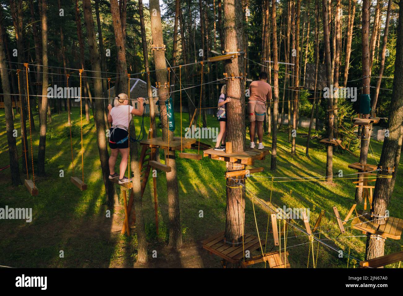 A woman overcomes an obstacle in a rope town. A woman in a forest rope ...
